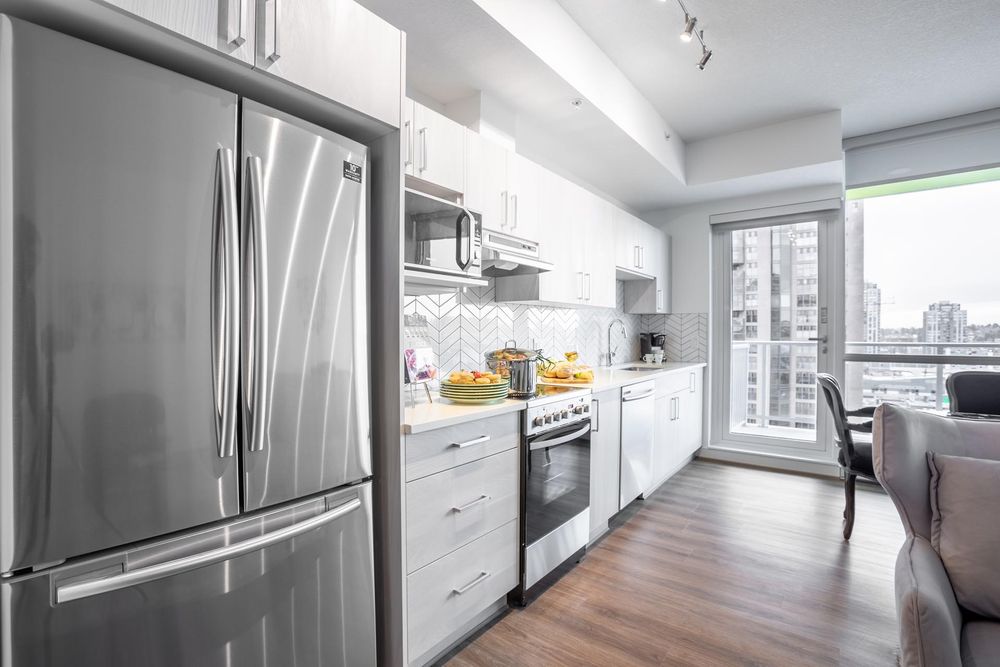 Kitchen with a French-door fridge and window at the end